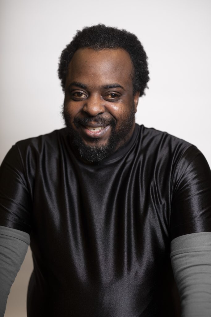 Hombre sonriente con camisa negra, foto de retrato.